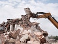 Old building demolition. Excavator working in rubble.