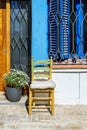 An old building with an entrance framed by a chair and potted plant, illuminated in the daytime light shining through its windows Royalty Free Stock Photo