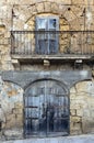 Old building front showing garage and window above balcony Royalty Free Stock Photo