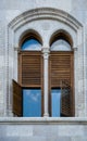 The old building from gray concrete blocks with narrow and beautiful windows with wooden sun blind. Royalty Free Stock Photo