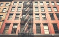 Old building with iron fire escape, color toning applied, New York City, USA