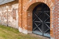 Entrance to medieval old castle. Ancient red brick wall with a wooden doors Royalty Free Stock Photo