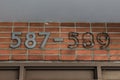 Old building number on a brick wall, with some of the numbers missing