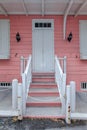 Old building painted with white and pink oil paint, paint peeling, iron locks Royalty Free Stock Photo