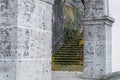 Old building ruins with stone column archway and overgrown stone stairway Royalty Free Stock Photo