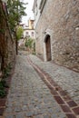 Old building with wooden door on empty village road that is made of stone Royalty Free Stock Photo