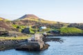 Old buildings and boat at the coastline of island of Heimaey in Iceland