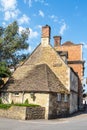 Old buildings in an English village with multiple chimneys under a pretty blue cloudy sky Royalty Free Stock Photo