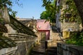 Old buildings by stone stairway on slope in sunny morning