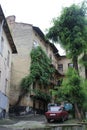 Old buildings, tenement houses with a yard, balconies and parked cars among the greenery
