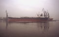 Old bulk carrier ship in a fog in Gdansk harbor