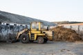 Old bulldozer near heap of manure