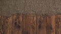 Old burlap fabric napkin on brown wooden background, top view Royalty Free Stock Photo