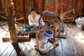 Old burmese woman is spinnig a lotus thread