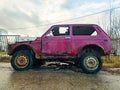 Old burnt-out car is red. An abandoned car against the background of gray panel houses Royalty Free Stock Photo