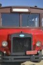 Old bus, red and brown, seen from the front, with headlights, windshield, in intentional cropped phot Royalty Free Stock Photo