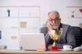 Old male employee being awarded with golden cup Royalty Free Stock Photo