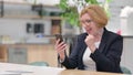 Old Businesswoman with Success on Smartphone in Office