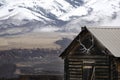 Old Cabin with Snow Mountains and Elk Antlers Royalty Free Stock Photo