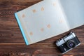 Old camera and empty photo album on wooden background Royalty Free Stock Photo