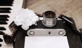 old camera, film, piano, white flower