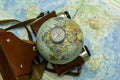 an old camera on a geographical map of the world instead of a globe lens the concept of travel tourism Royalty Free Stock Photo