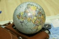 an old camera on a geographical map of the world instead of a globe lens the concept of travel tourism Royalty Free Stock Photo