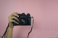 Old camera in one female hand on a pink background Royalty Free Stock Photo