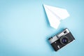 Old camera and paper plane on blue background Royalty Free Stock Photo