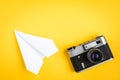 Old camera and paper plane on yellow background Royalty Free Stock Photo