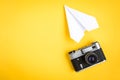 Old camera and paper plane on yellow background Royalty Free Stock Photo