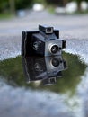 Old camera in puddle of water