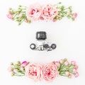 Old camera and roses, buds and leaves on white background. Flat lay, top view. Retro background. Royalty Free Stock Photo