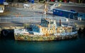 Old camouflage painted boat named Sealion moored at city wharf