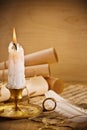 Old candle on table with rolls of paper Royalty Free Stock Photo