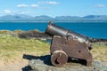 Old cannon on Anglesey Island, Menai Strait and Snowdonia mountains in the background