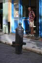 An old cannon and a tourist standing in the doorway of a restaurant. Obispo street