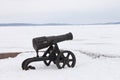 Old cannon on a winter snow-covered embankment