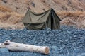 An old canvas tent after storm on rocky seashore Royalty Free Stock Photo