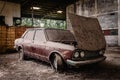 Old car with dust and dirt stuck in an abandoned building. Royalty Free Stock Photo