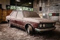 Old car with dust and dirt stuck in an abandoned building. Royalty Free Stock Photo