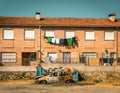 Old car parked in front of a brick building with laundry hanging on the windows. Royalty Free Stock Photo