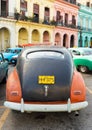 Old car parked near colorful buildings in Havana Royalty Free Stock Photo