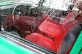 Old car. Red chairs and wheel. The window is covered by raindrops Royalty Free Stock Photo