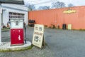 Old car repair shop with a gas station, advertising for cheap ga