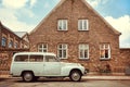 Old car on street with historical brick house. Vintage auto parked in city area Royalty Free Stock Photo