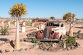 Old car in a succulent garden between flowering quiver trees
