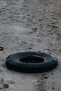 A old car tire dumped in the beach. Royalty Free Stock Photo