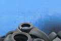 An old car tires stacked on blue background in a pile in area a car workshop, disposal recycling concepts