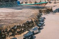 Old car tires used as for strengthening concrete sidewalk area built on sandy beach at high tide water level, perspective view